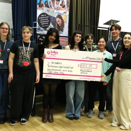 members of the sixth form fundraising committee present a cheque to St.Lukes